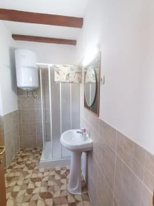 a bathroom with a sink and a shower with a mirror at La Nera in Sasca Română