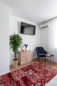 - un salon avec une chaise bleue et une commode dans l'établissement Luxury Apartment Slava Ukraini, à Ivano-Frankivsk