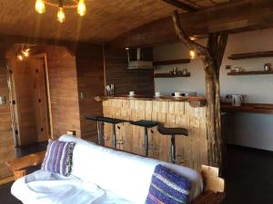 a living room with a couch and a kitchen at CABAÑA LA RECALADA in Castro