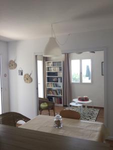 a living room with a table and a room with a book shelf at La vigie in Cavalaire-sur-Mer
