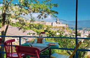 d'une table et de chaises sur un balcon avec vue sur le château. dans l'établissement Clockwise GuestRooms, à Gjirokastër