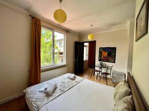 a bedroom with a bed and a window and a table at LA CASA in Tbilisi City