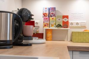 a kitchen counter with a coffee maker and books at #1 modernes Zimmer mit Pool und Garten in Memmingen