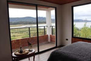 um quarto com uma cama e vista para a água em Hotel Villa Blanca Guatavita em Guatavita