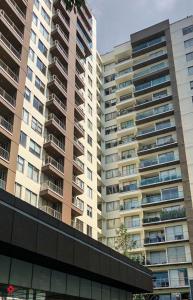 a large apartment building with tall buildings in the background at Casa Vive Grand by Kukun in Mexico City