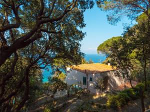 dom na wzgórzu z oceanem w tle w obiekcie Villa I Coralli w mieście Portoferraio