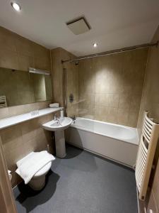 a bathroom with a tub and a toilet and a sink at Chinatown Suite in Birmingham