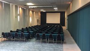 a conference room with chairs and a screen in it at Hotel Hacienda Cola del Caballo in Santiago