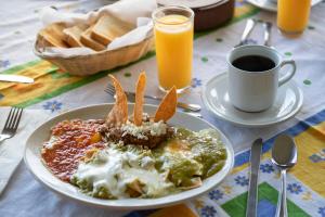 a plate of food on a table with a cup of coffee at Hotel Hacienda Cola del Caballo in Santiago