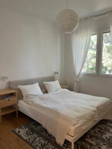 - une chambre blanche avec un grand lit et une fenêtre dans l'établissement MiasApp, à Vienne