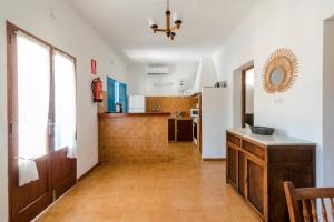 a kitchen with white walls and a wooden floor at Casa Vicent Campanitx Es Pujols in Es Pujols