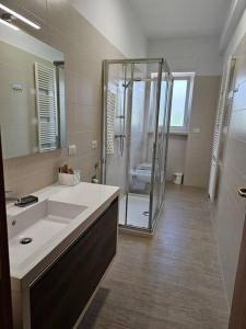 a bathroom with a shower and a sink and a mirror at Casa vacanze Moretto in Ceglie Messapica