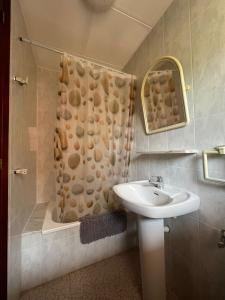 a bathroom with a sink and a shower with a shower curtain at Rural Sant Llop in Tordera