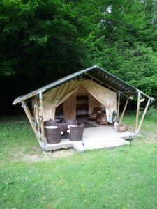 um gazebo com cadeiras e um deque na relva em Tente lodge Élevage Girbal em La Chapelotte