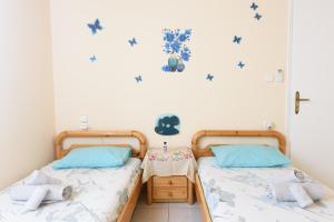 2 łóżka pojedyncze w sypialni z niebieskimi ścianami w obiekcie Helen's house w mieście Igoumenitsa