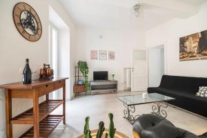 a living room with a black couch and a table at Casetta Lago Maggiore in Maccagno Superiore