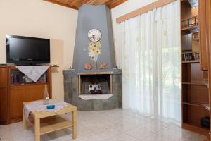 uma sala de estar com lareira e televisão em Helen's house em Igoumenitsa