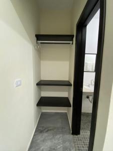 a walk in closet with black shelves and a sink at Hotel La Isla in Cunduacán