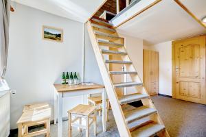 una escalera que conduce a una habitación con una mesa y botellas de vino en Pension Barborka, en Boží Dar