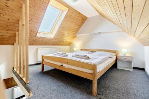 a bedroom with a large bed in a attic at Pension Barborka in Boží Dar