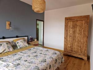 1 dormitorio con 1 cama y puerta de madera en Aux murmures de la nature, en Vaunaveys