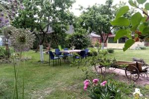 a garden with a table and chairs and flowers at "Šventvakarė" in Liaunai