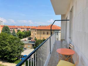 balcón con mesa y vistas a los edificios en Angela: vacanza e/o lavoro, en Nichelino
