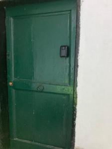 a green door with a window in a wall at L'Incantesimo in Triora