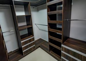 a walk in closet with wooden shelves and cabinets at Sleep Well in Filandia