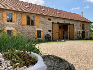 una casa de piedra con un jardín delante de ella en Chambres et table d'hôtes : LES SENTIERS DE LA BREME 