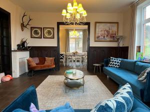 sala de estar con sofá azul y mesa en Les 3 Soeurs, en Han-sur-Lesse