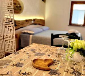 einem Tisch mit einem Tischtuch mit einem hölzernen Herz darauf in der Unterkunft Emozioni al Lago in Farra dʼAlpago