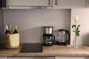 a kitchen counter with a blender and bottles of wine at Modern Loft Syros in Ano Syros +36 photos
