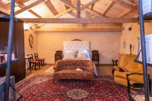 a bedroom with a bed and a couch and chairs at Descubre La Cepedana: Casa rural con encanto en Cogorderos, a solo 10 km de Astorga in Cogorderos