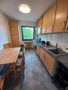 a kitchen with a wooden table and a sink at Dora, impressionistischen Stil in Bergheim