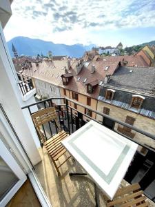 a balcony with chairs and a view of a city at T3 de 73 m2 , garage , vue montagnes et château in Annecy