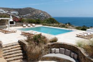 una piscina con sedie e vista sull'oceano di Villa Etcetera a Elia Beach