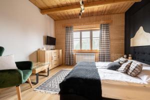 ein Schlafzimmer mit einem Bett, einem Stuhl und einem Fenster in der Unterkunft Domek Hacienda in Kościelisko
