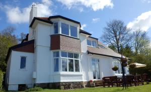 a white house with a table and chairs at The Knowe Guest House in Callander