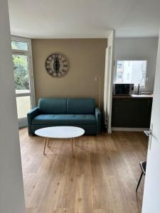 sala de estar con sofá azul y mesa en Bel appartement à 25 mn de Paris, en Sartrouville