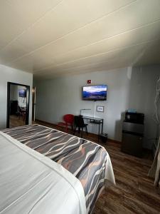 a bedroom with a bed and a desk and a tv at Valued Stay Aloha in Madison