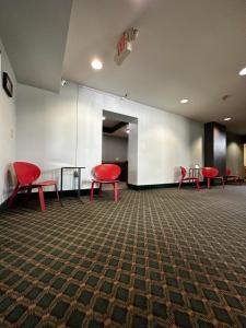 a waiting room with red chairs and a table at Valued Stay Aloha in Madison