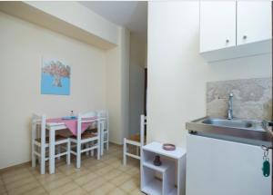 a kitchen with a sink and a table with chairs at Eleni in Kissamos