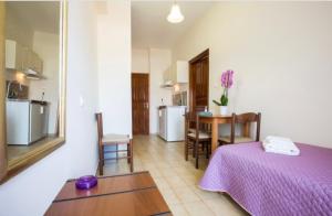 a room with a bed and a table and a kitchen at Eleni in Kissamos