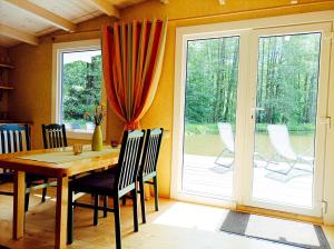 a dining room with a table and chairs and a sliding glass door at Reed Cottage in Dzenkuniskes