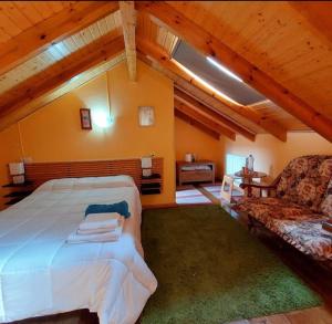 1 dormitorio con 1 cama grande y 1 sofá en Apartahotel portal de leon, en Caboalles de Abajo