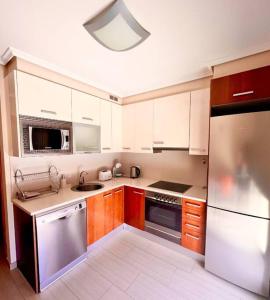 3-bedrooms apartament Vista Roja في غراناديا دي أبونا: مطبخ مع دواليب بيضاء وثلاجة ستانلس ستيل