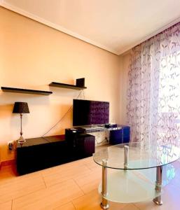 uma sala de estar com uma mesa de vidro e uma televisão em 3-bedrooms apartament Vista Roja em Granadilla de Abona
