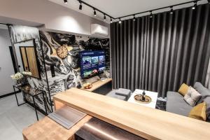 Una sala de estar con un sofá y un televisor. en EXCLUSIVE APARTMENTS ZATOR, en Zator