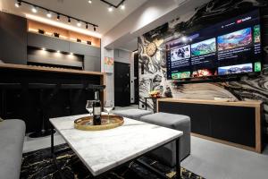 Un bar con una mesa y una pantalla grande. en EXCLUSIVE APARTMENTS ZATOR, en Zator